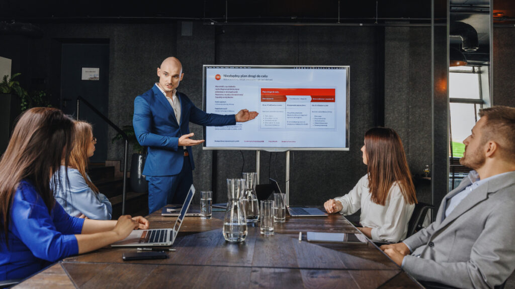 Prezentacja strategii marketingowej przed zespołem, przedstawiająca audyt i weryfikację kluczowych założeń marketingowych.